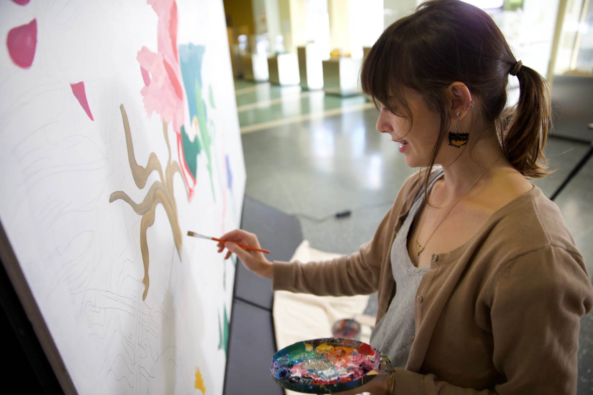 Cayla Zeek paints the mural by hand, capturing the human craft the technology was there to serve.